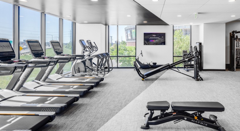 Large fitness center with windows overlooking downtown denver