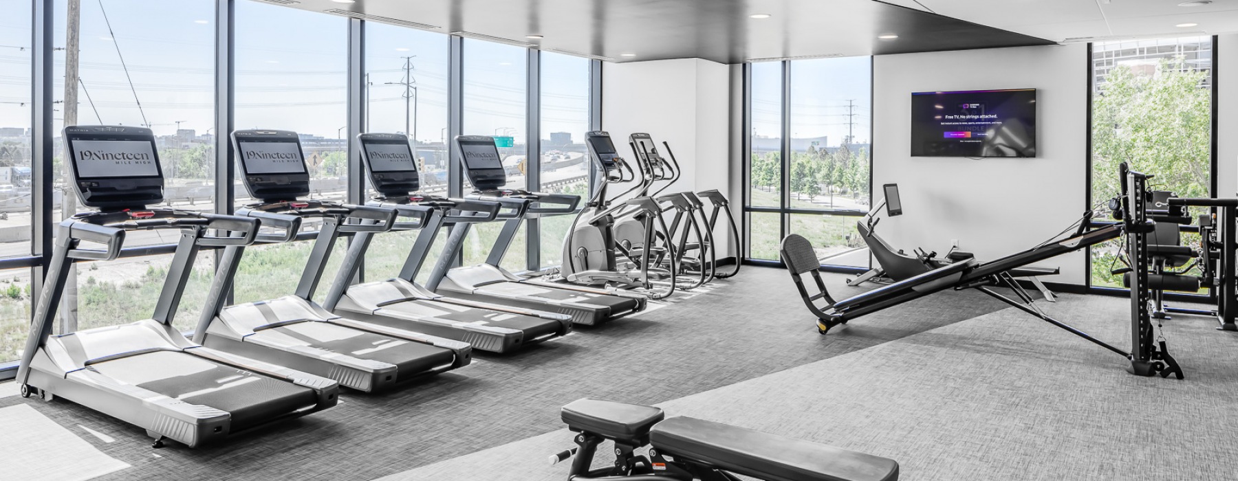 Fitness center with windows and cardio equipment
